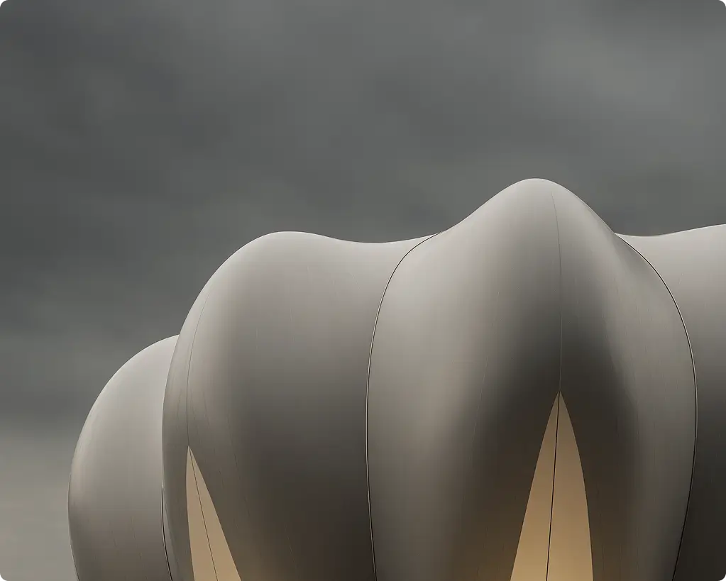 Close-up of futuristic white curved architectural structure segments under a gray cloudy sky.