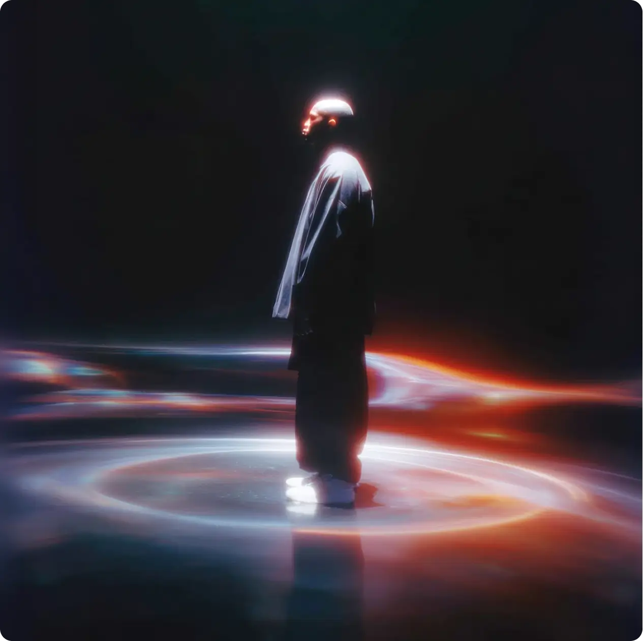 Silhouetted person standing in glowing circular light patterns on a dark reflective floor with colorful hues.